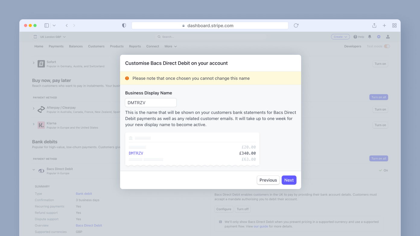 Customize Bacs Direct Debit settings for your account, displaying the Business Display Name "DMTRZV" and a note about its visibility on customer bank statements. Options to navigate to "Previous" or "Next" are available.