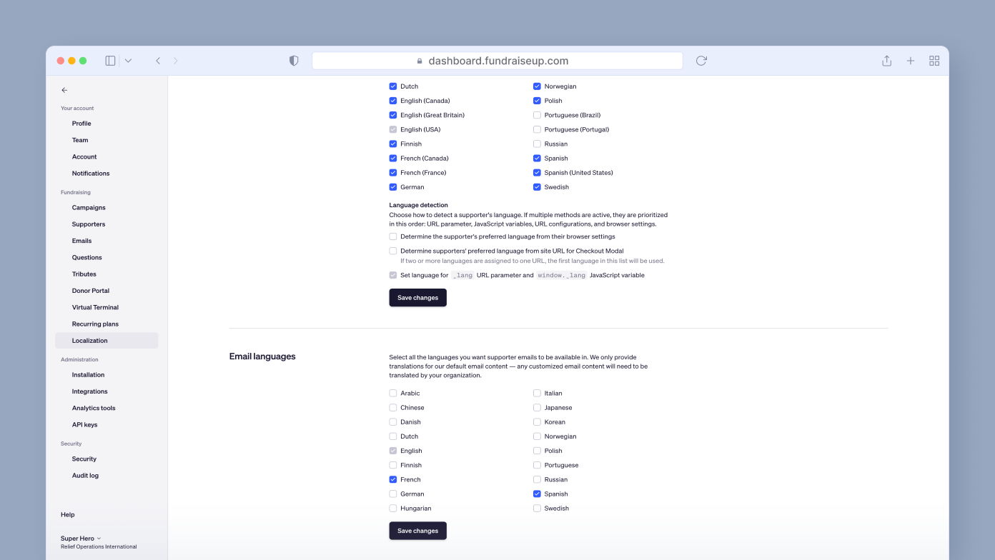 Language settings for a dashboard, showing options to select supported languages for user interface and email communications, with checkboxes for various languages and a "Save changes" button at the bottom.